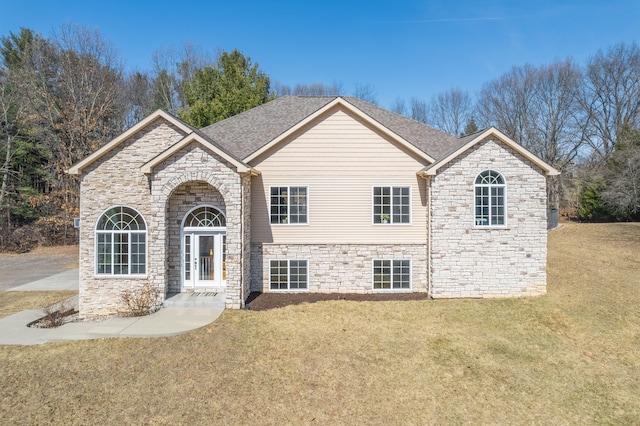 view of front of home featuring french doors, stone siding, a front yard, and a shingled roof