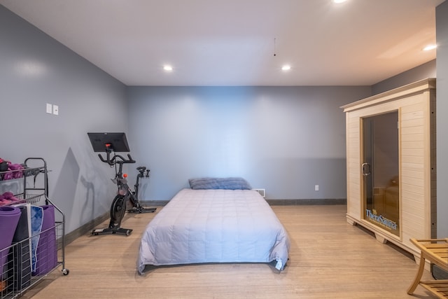 bedroom with recessed lighting, light wood-style flooring, and baseboards