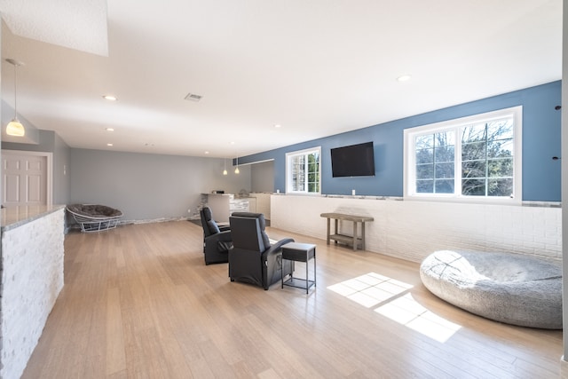 living area with recessed lighting, visible vents, and wood finished floors