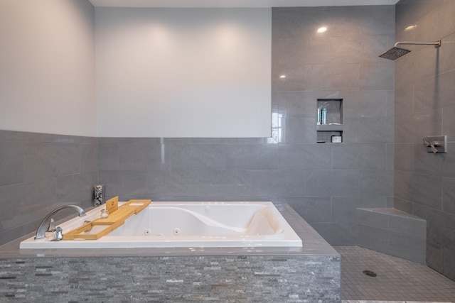 bathroom featuring a jetted tub and tiled shower