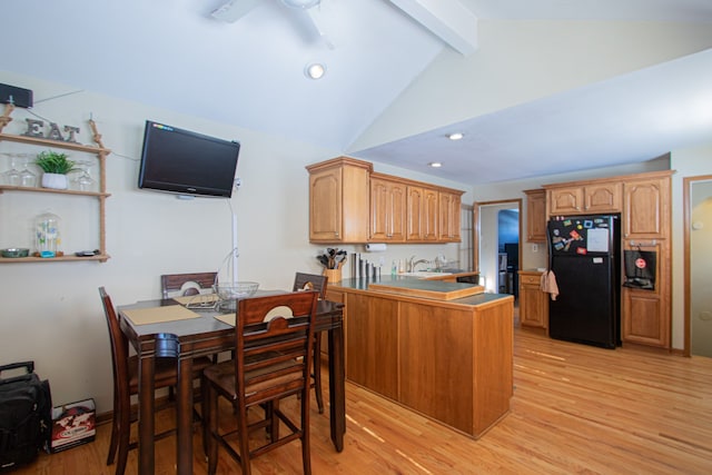 kitchen with recessed lighting, lofted ceiling with beams, light wood-style floors, freestanding refrigerator, and a peninsula