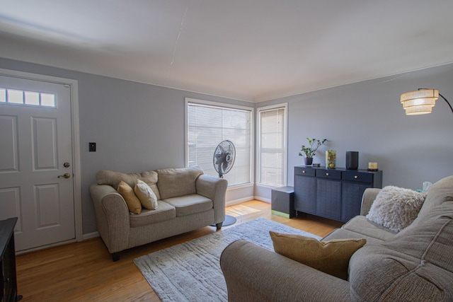 living area featuring light wood-style floors and baseboards