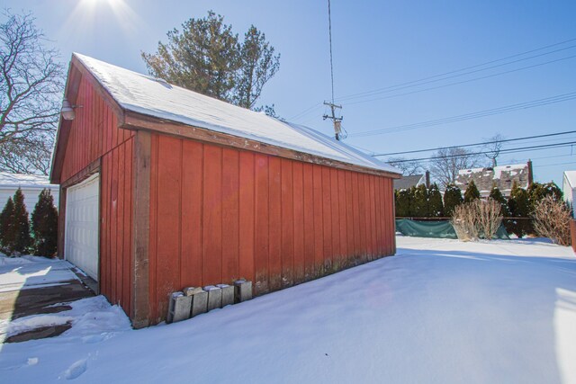 snow covered structure featuring an outbuilding