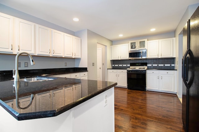 kitchen with a peninsula, a sink, range with gas cooktop, stainless steel microwave, and black refrigerator with ice dispenser