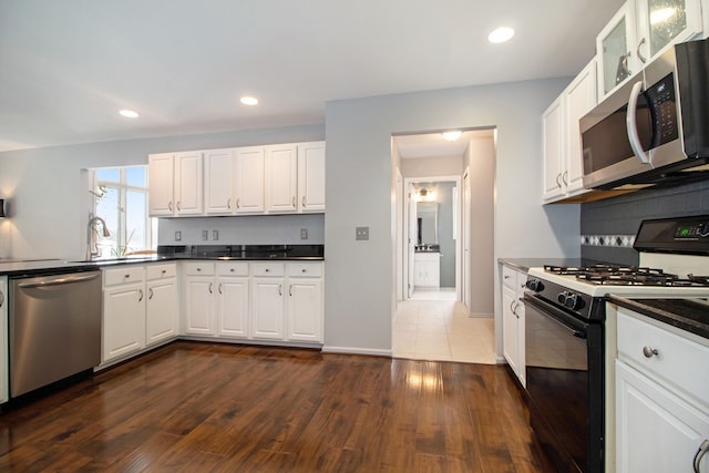 kitchen featuring dark wood-style floors, recessed lighting, appliances with stainless steel finishes, white cabinets, and decorative backsplash