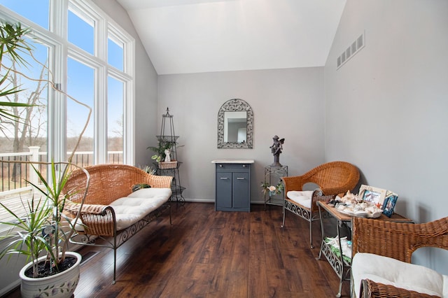 sitting room featuring lofted ceiling, visible vents, and dark wood-type flooring