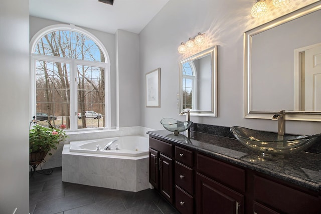 full bathroom featuring a tub with jets, plenty of natural light, and a sink