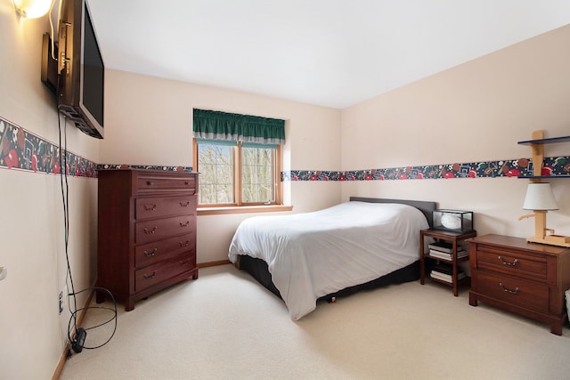 bedroom featuring baseboards and light carpet