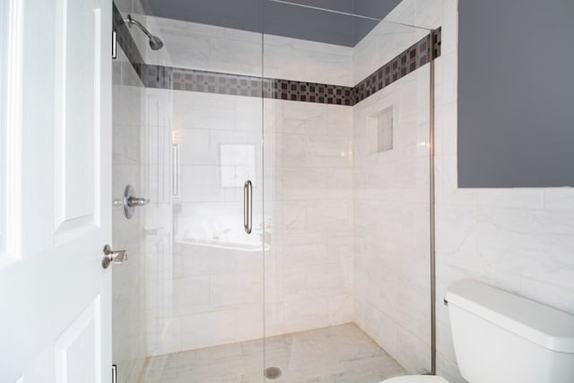 full bath featuring a stall shower and toilet