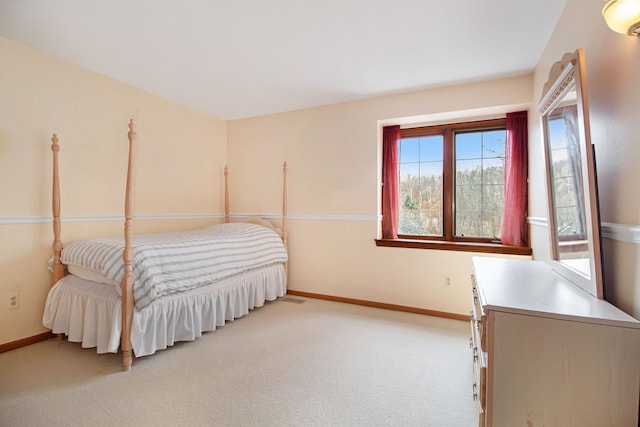 bedroom featuring light carpet and baseboards