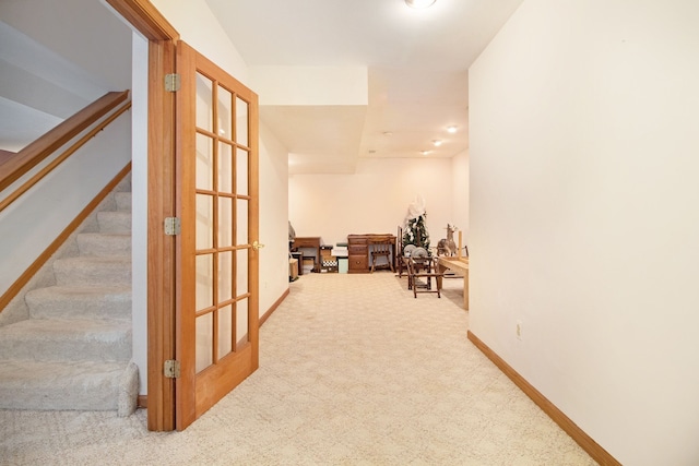 hallway with baseboards, carpet, and stairs