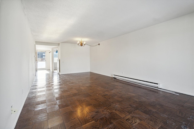 spare room with a textured ceiling, a baseboard radiator, baseboards, and an inviting chandelier