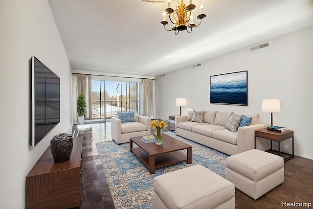 living room featuring baseboards, visible vents, and a notable chandelier