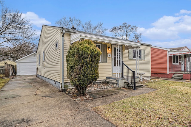 view of front of home featuring an outbuilding, a detached garage, a front lawn, and entry steps