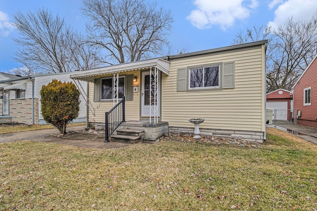 bungalow-style house featuring an outbuilding, a front lawn, and a garage