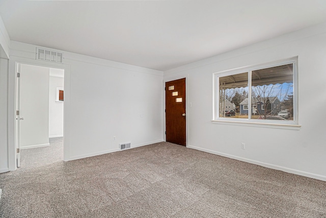 carpeted spare room featuring visible vents and baseboards