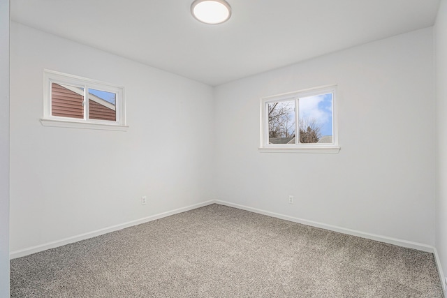 unfurnished room with carpet floors and baseboards