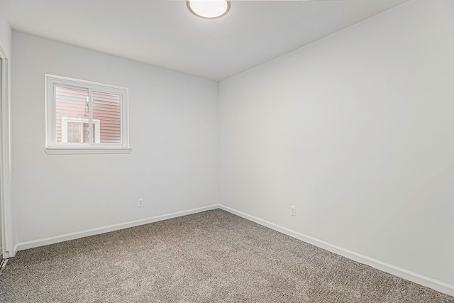 carpeted empty room with baseboards