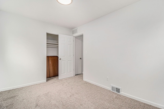 unfurnished bedroom with baseboards, visible vents, and light colored carpet