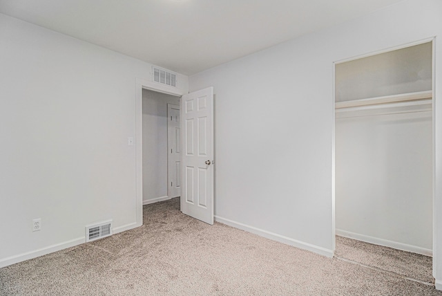 unfurnished bedroom with carpet, a closet, visible vents, and baseboards