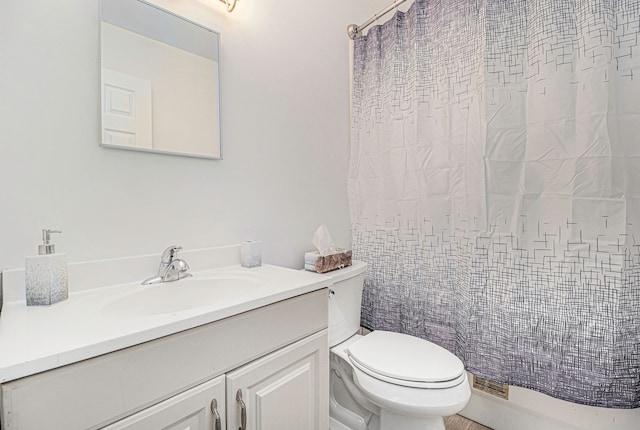 full bathroom featuring a shower with shower curtain, vanity, and toilet