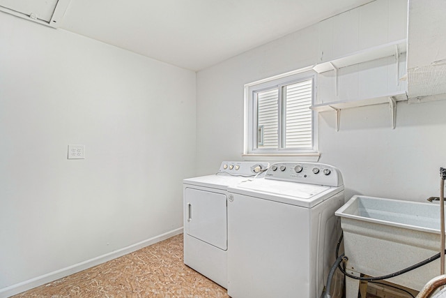 laundry area with laundry area, a sink, baseboards, and separate washer and dryer