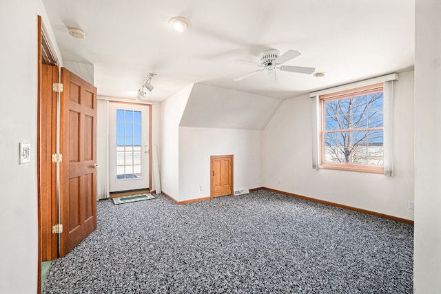 additional living space with plenty of natural light, baseboards, lofted ceiling, and carpet