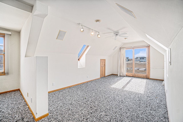 additional living space with carpet flooring, vaulted ceiling, plenty of natural light, and baseboards