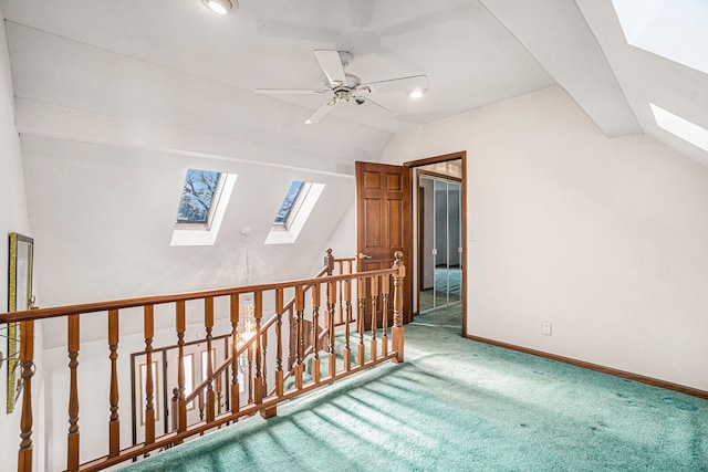 additional living space with lofted ceiling with skylight, a ceiling fan, baseboards, and carpet floors