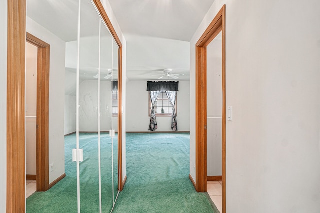 hall featuring baseboards and light carpet
