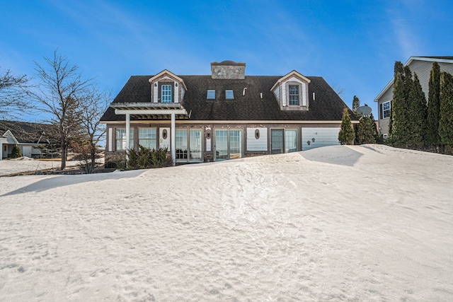 view of front of property featuring a garage, a chimney, and a pergola