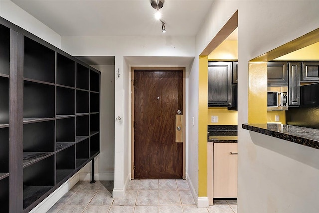 interior space featuring baseboards and light tile patterned floors