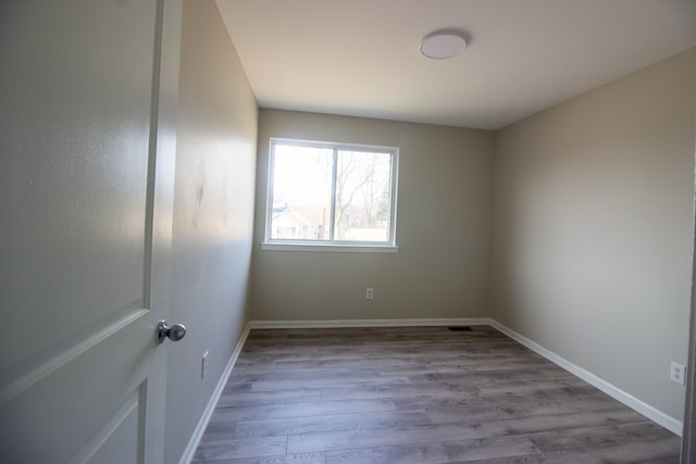 spare room with wood finished floors and baseboards