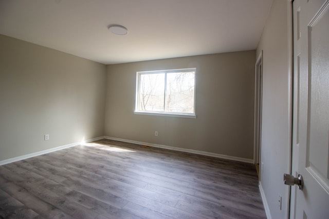 unfurnished bedroom featuring visible vents, baseboards, and wood finished floors