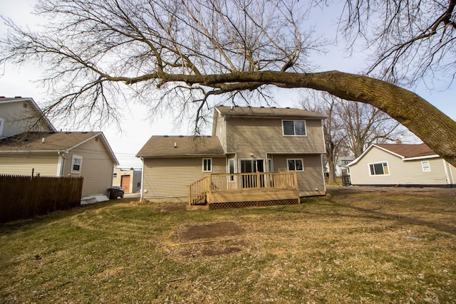 rear view of property with a yard, fence, and a wooden deck