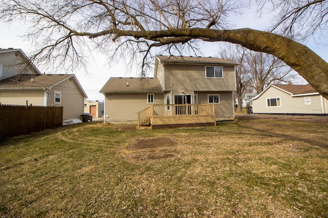 back of house with fence, a deck, and a lawn