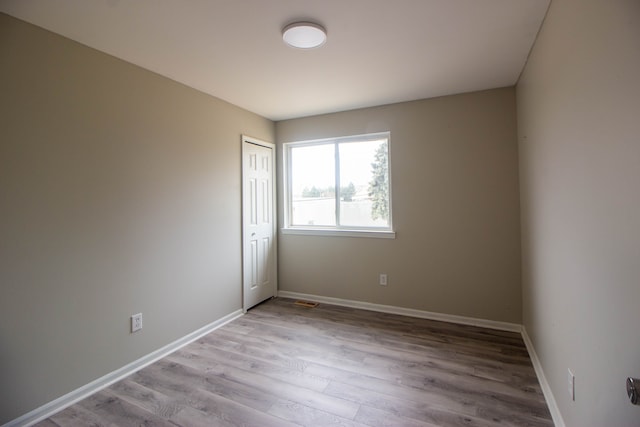 empty room with baseboards and wood finished floors