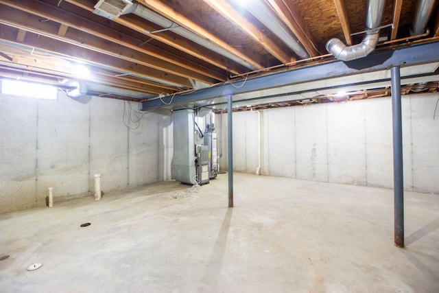 unfinished below grade area featuring gas water heater and heating unit