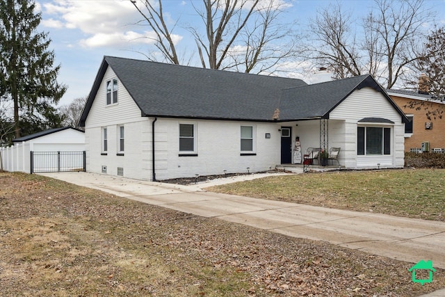 view of front facade with a shingled roof, brick siding, a chimney, and a front lawn