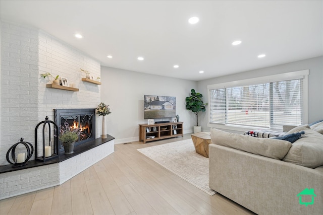 living area with recessed lighting, a fireplace, baseboards, and wood finished floors