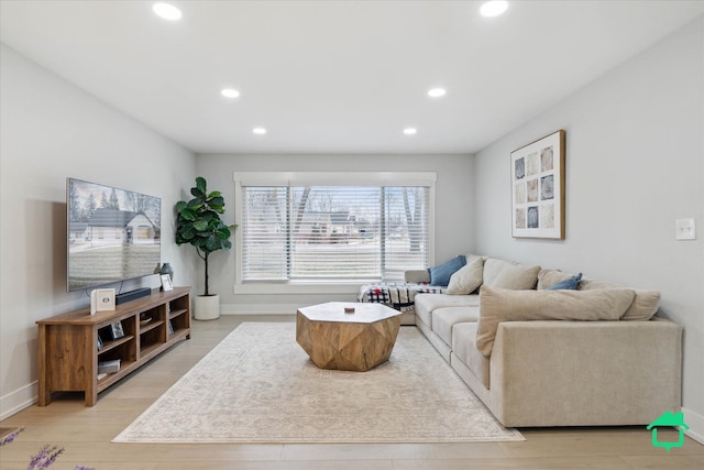 living area with baseboards, light wood finished floors, and recessed lighting