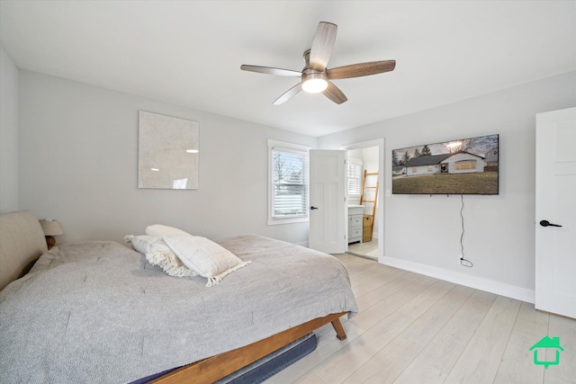 bedroom with light wood-style floors, ceiling fan, baseboards, and connected bathroom