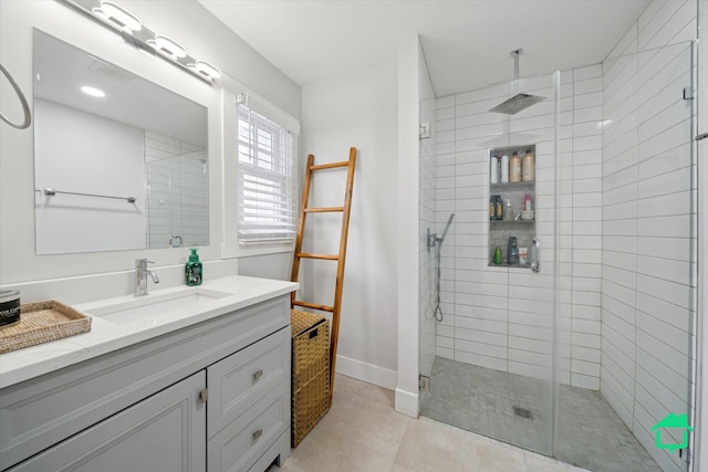 full bath featuring a stall shower, tile patterned flooring, vanity, and baseboards