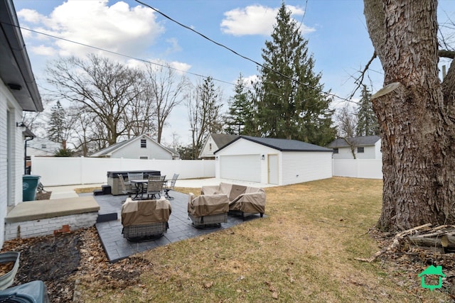 view of yard with a detached garage, a patio area, a fenced backyard, and an outdoor structure