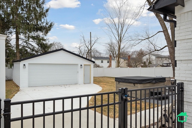 view of yard featuring an outbuilding, a detached garage, and fence private yard