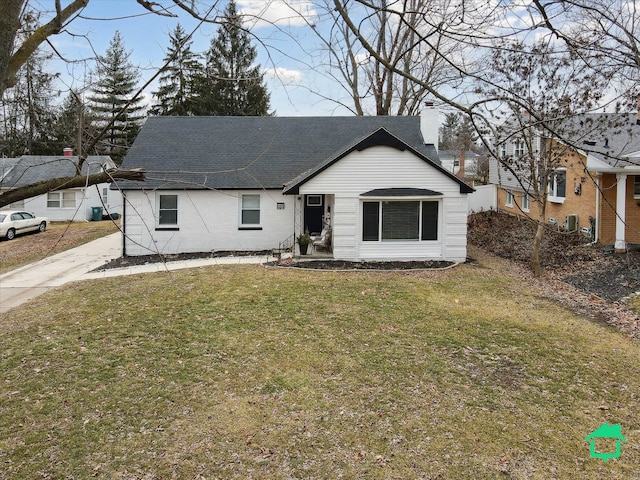 view of front of home featuring a shingled roof, a chimney, and a front yard