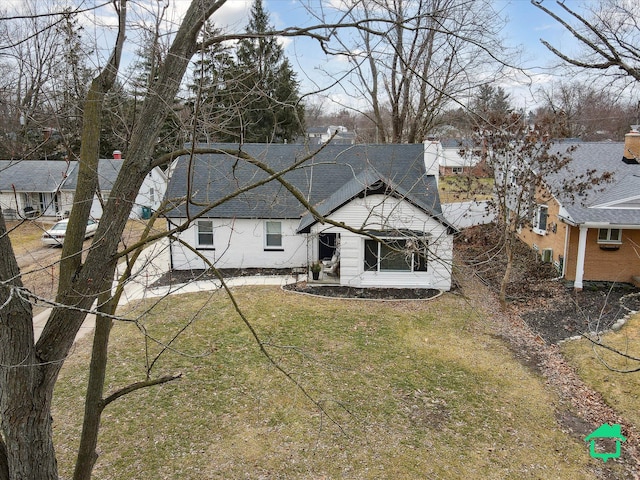 view of front of home with a shingled roof and a front lawn