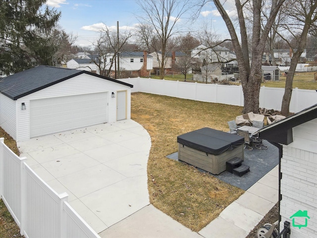 view of yard featuring a residential view, a detached garage, a fenced backyard, and an outdoor structure