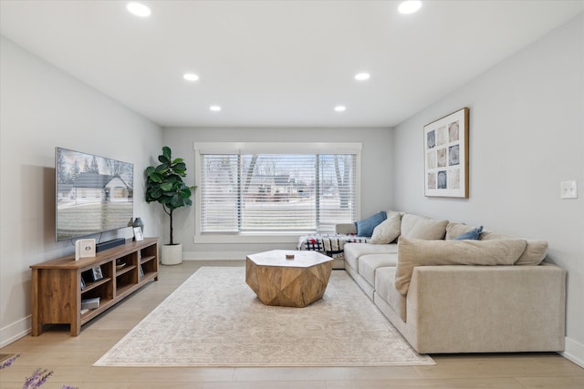 living area with recessed lighting, light wood-type flooring, and baseboards