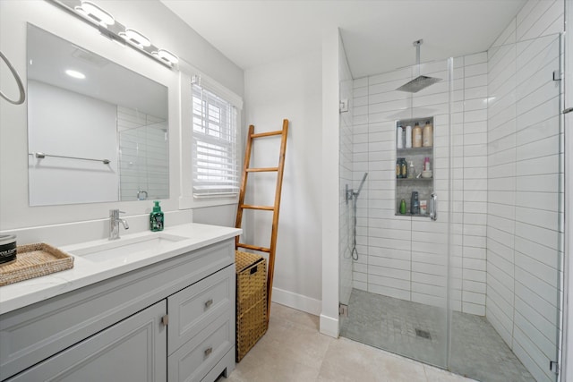 bathroom featuring tile patterned floors, a shower stall, vanity, and baseboards